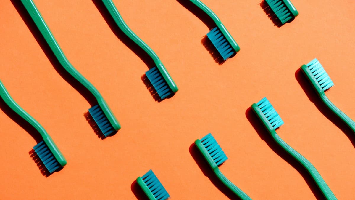 Toothbrushes on orange background dentist in Washington MI