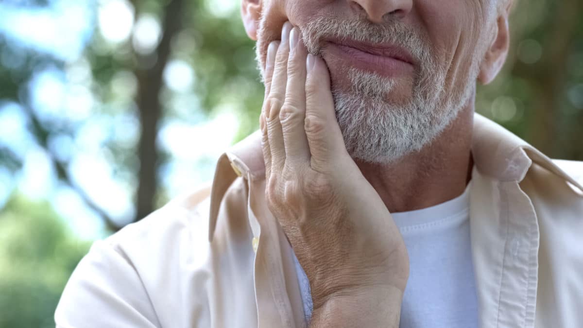 Older man with white beard with gum disease at Washington MI dentist